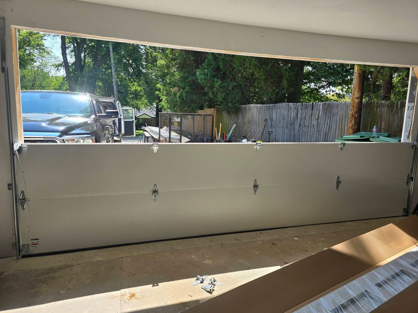 Garage door installation in progress with only the bottom panels set in the opening