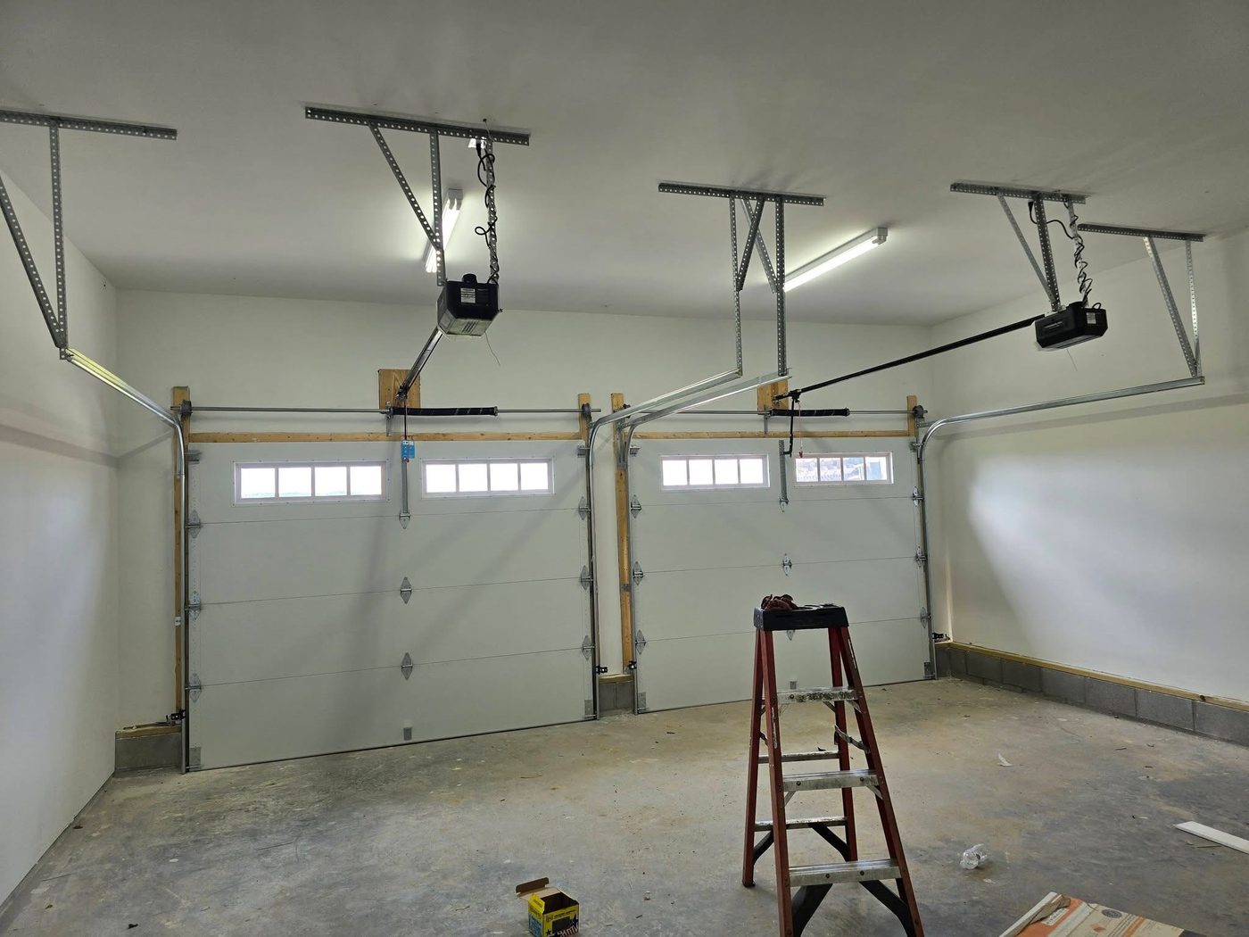 Two garage doors and openers installed in a new construction garage