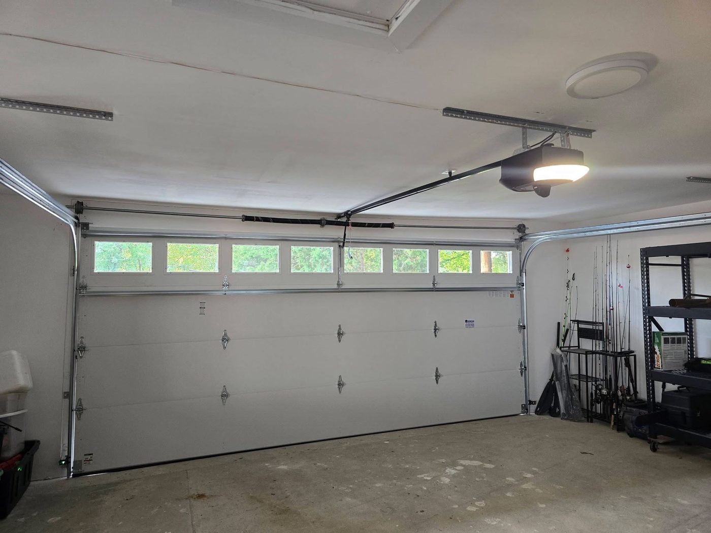 Completed residential garage door and opener installed in a finished garage